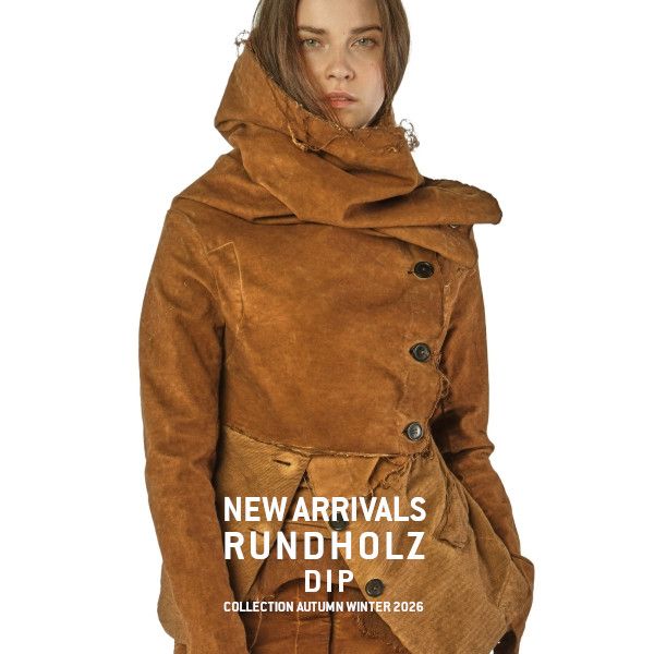 Frau trägt rustikalen Rundholz-Dip-Mantel aus der Herbst-Winter-Kollektion 2026.
